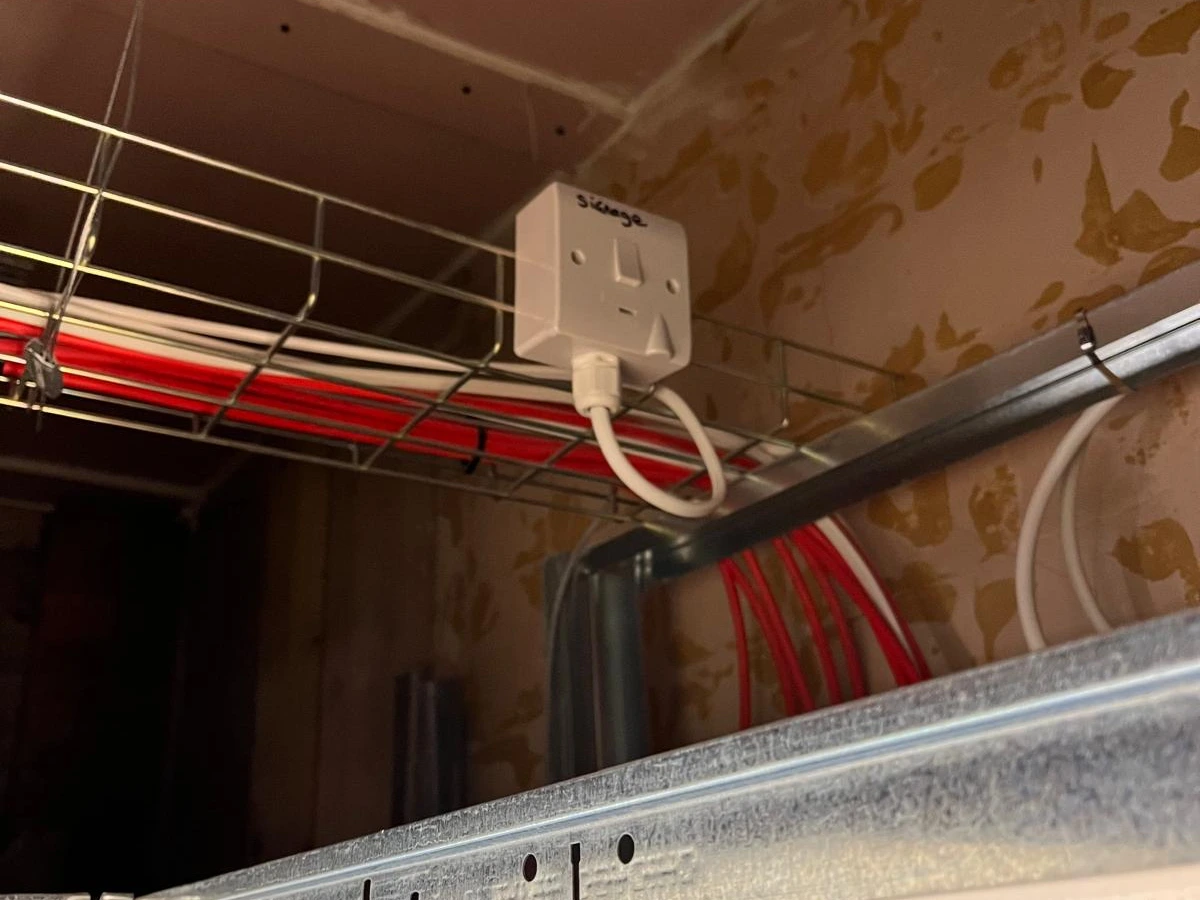 Electrical socket and cable tray installation above a commercial suspended ceiling