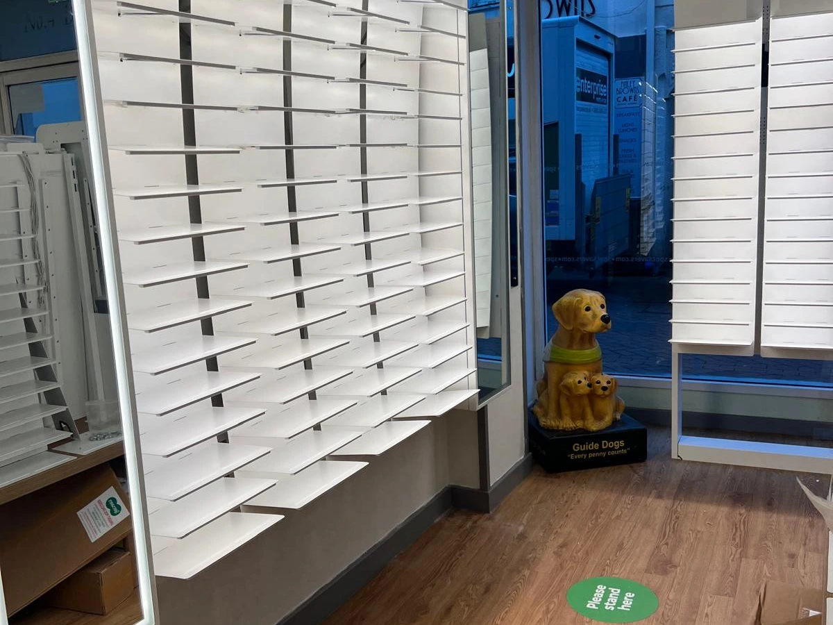 Illuminated display shelving and mirror lighting installed for an optician retail fit-out